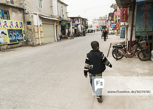 Junger Junge geht auf der Straße des Dorfes Tapu; Xiamen  Provinz Fujian  China