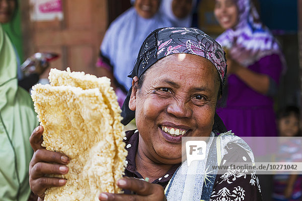 Frau verkauft Reiskuchen auf dem Wochenmarkt  Semparu  Lombok  West Nusa Tenggara  Indonesien