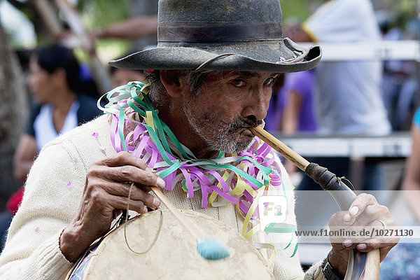 Man Playing An Erque  Whilst Drumming On A Caja In The Entrada De Comadritas Parade During The Carnaval Chapaco  Tarija  Bolivia