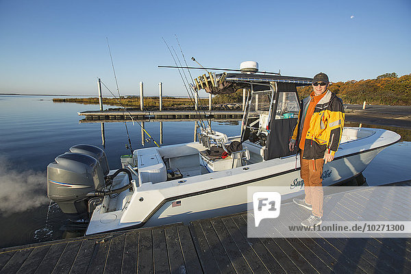 Fischer steht auf einem Dock neben seinem Boot; Montauk  New York  Vereinigte Staaten von Amerika