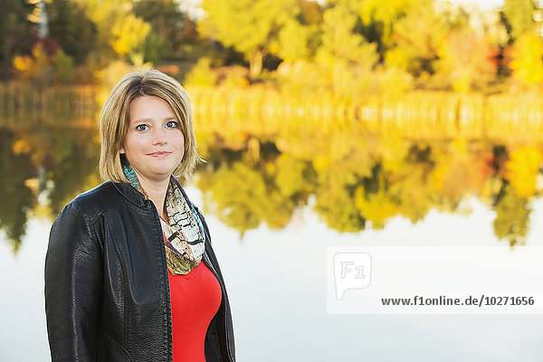 Porträt einer reifen Frau in einem Park an einem See im Herbst; Edmonton  Alberta  Kanada'.