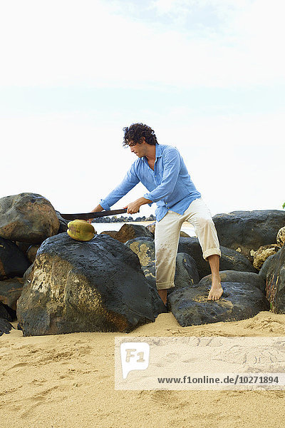 Mann steht auf Felsen am Lydgate Beach; Kauai  Hawaii  Vereinigte Staaten von Amerika'.