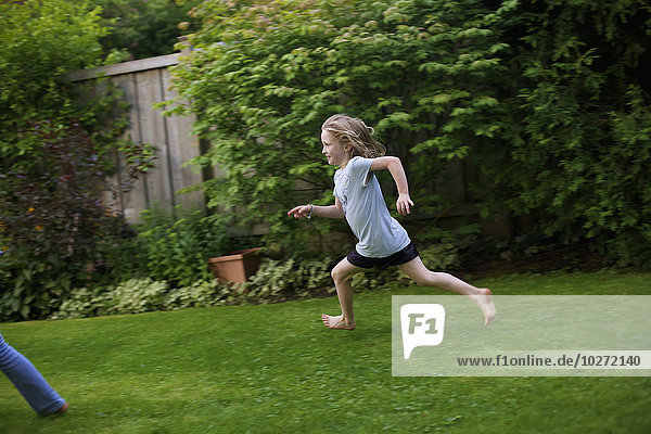 'Young girl running in a backyard; Picton  Ontario  Canada'