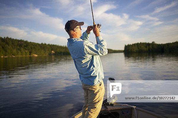 Mann mit einem Fisch an der Leine; Ontario  Kanada'.