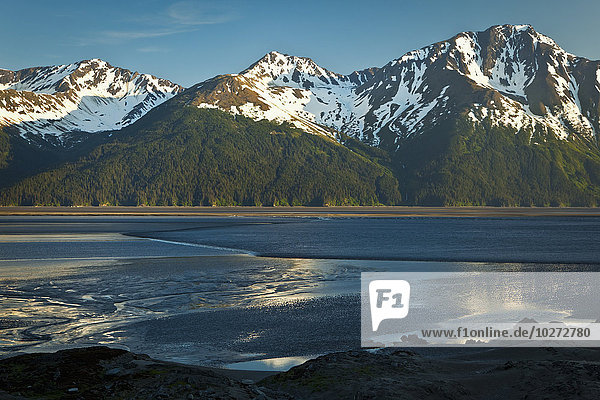'Tidal bore across Turnagain Arm of Cook Inlet  Chugach Mountains in the background; Alaska  United States of America'