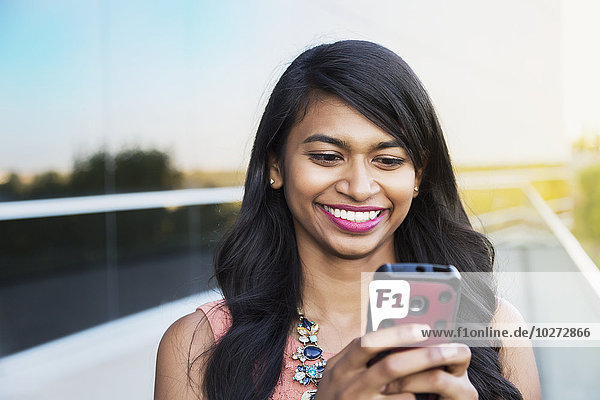 'Young professional businesswoman texting on her smart phone; Edmonton  Alberta  Canada'