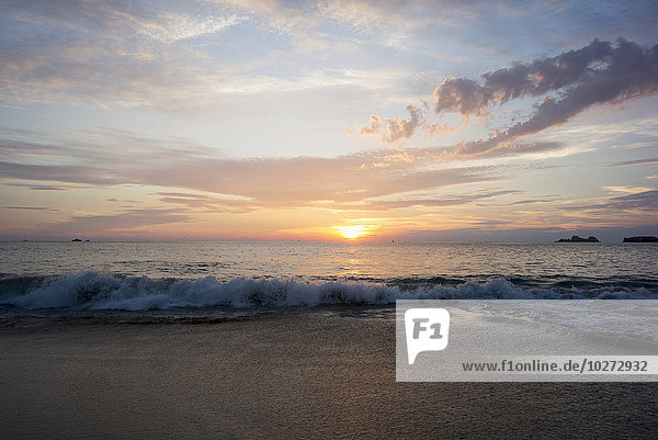 'Sunset over the horizon with waves rolling on the beach; Ixtapa-Zihuatanejo  Guerrero  Mexico'