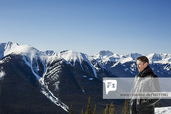Ein Mann steht mit Blick vom Sulphur Mountain auf die kanadischen Rockies im Winter; Banff  Alberta  Kanada'.