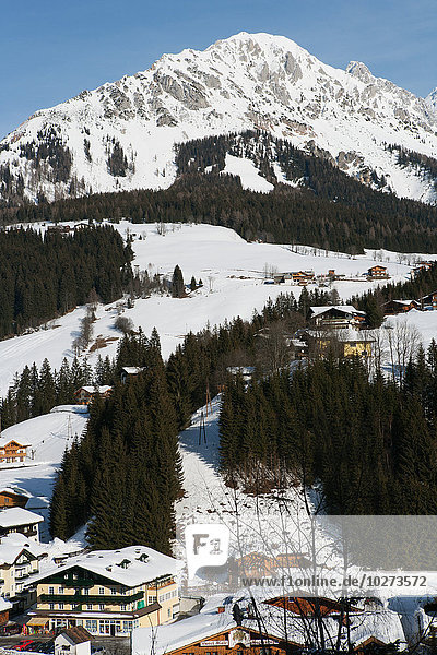 Berge  Skipisten  schneebedeckte Holzhäuser und Tannenbäume im alpinen Skigebiet Filzmoos  Österreich'.