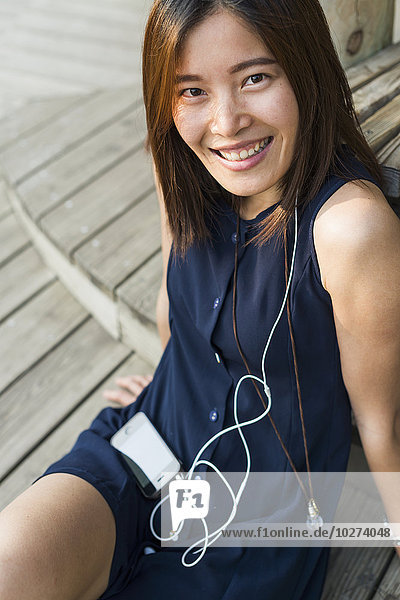 Chinesisches Mädchen lächelt und hört Musik; Xiamen  Provinz Fujian  China