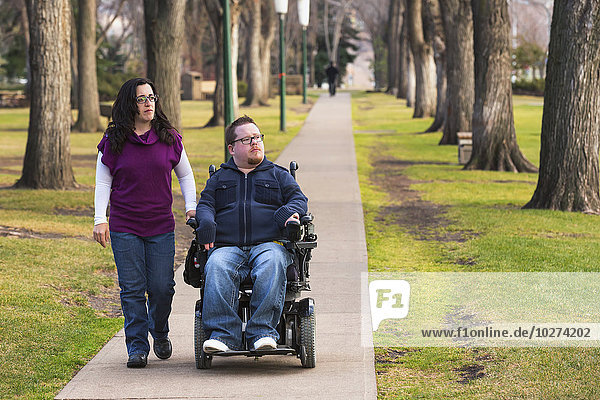 Behinderter Ehemann geht mit seiner Frau im Herbst in einem Park spazieren; Edmonton  Alberta  Kanada'.
