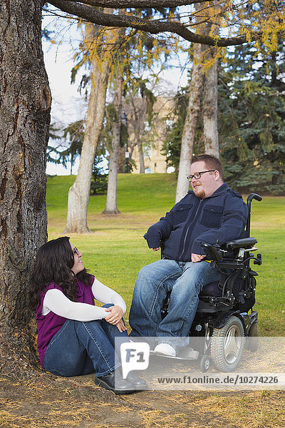 Behinderter Mann im Gespräch mit seiner Frau in einem Park im Herbst; Edmonton  Alberta  Kanada'.