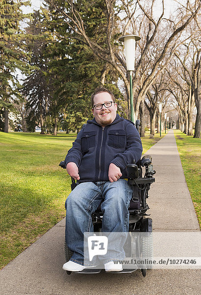 Behinderter Mann in seinem Elektrorollstuhl in einem Park im Herbst; Edmonton  Alberta  Kanada'.