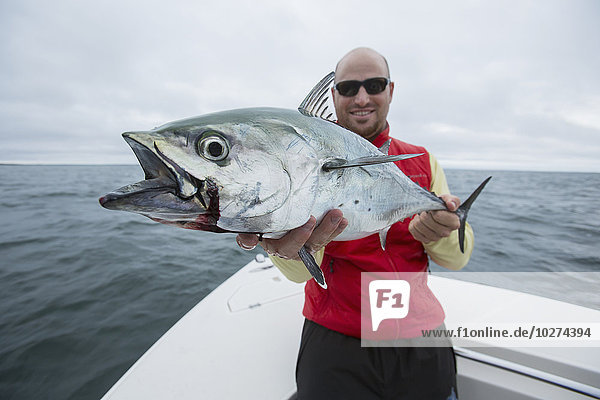 'Fisherman holding false albacor; Cape Cod  Massachusetts  United States of America'