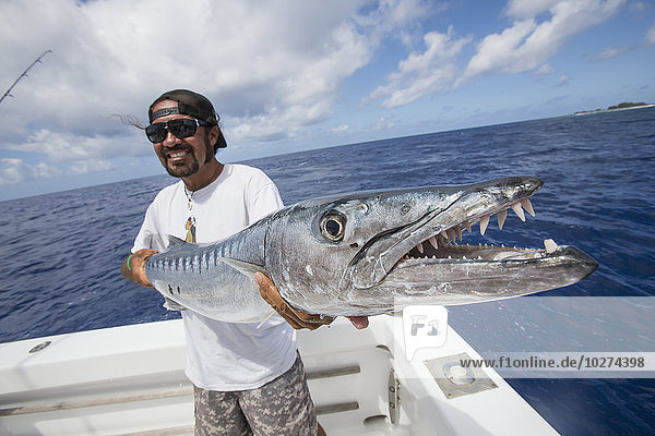 'Fisherman holding barracuda fish; Tahiti'