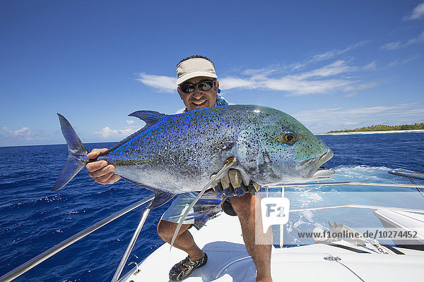 Fischer hält einen frisch gefangenen Jackfisch; Tahiti'.