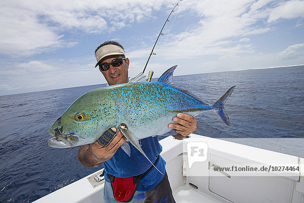 'Fisherman holding a fresh caught Jackfish tuna; Tahiti'