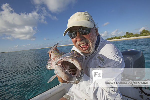 'Fisherman holding a fresh caught Grouper; Tahiti'