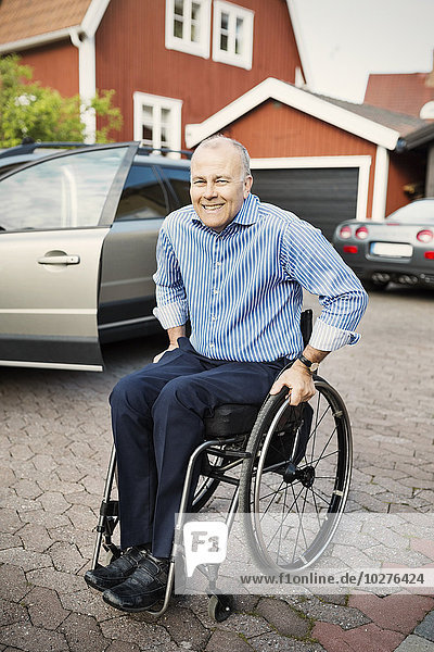 Porträt eines glücklichen Mannes im Rollstuhl auf der Straße