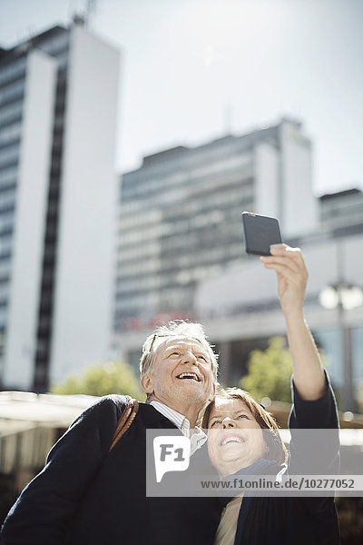 Seniorenpaar nimmt Selfie durch Smartphone in der Stadt mit