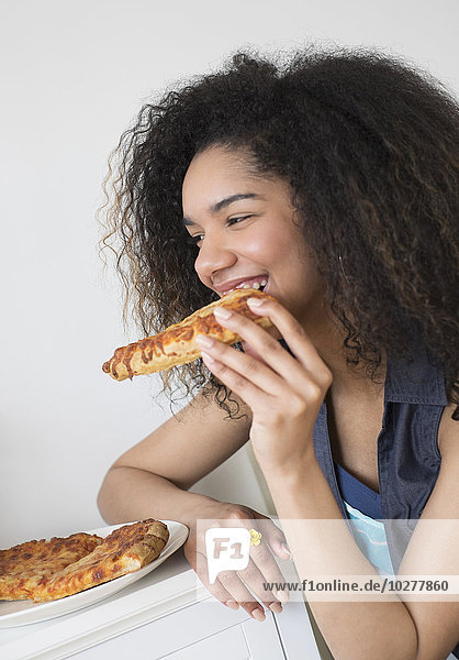 Teenage girl (16-17) eating pizza