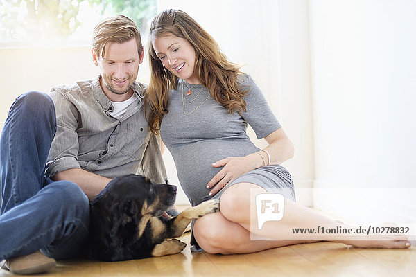 Couple relaxing with dog on floor