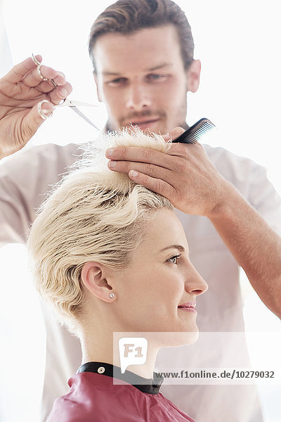 Hairdresser cutting woman's hair