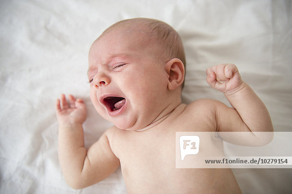 Baby-Mädchen (2-5 Monate) weint im Kinderbett