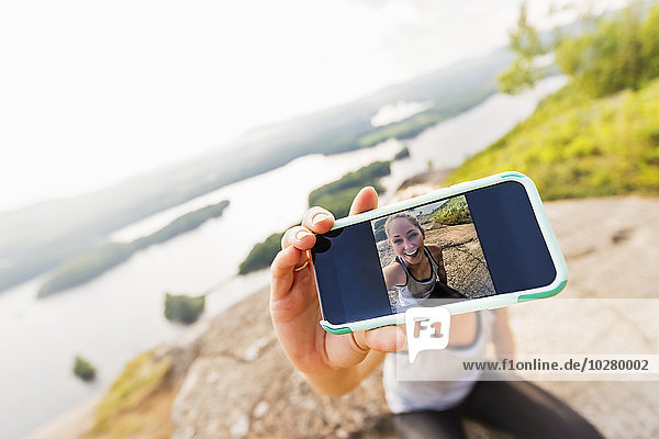 Junge Frau macht Selfie mit Smartphone