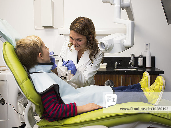 Zahnarzt und Patient (8-9) in der Praxis des Zahnarztes