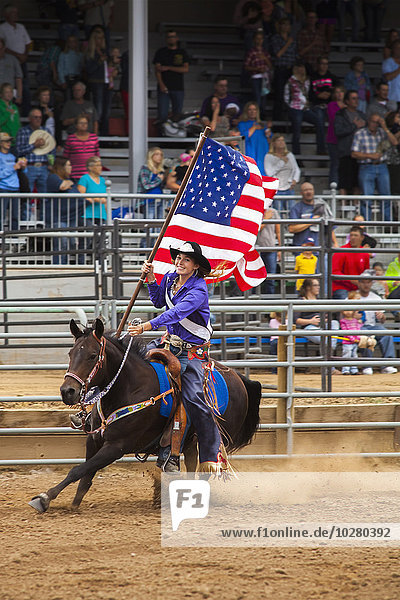 Frau auf Pferd mit amerikanischer Flagge