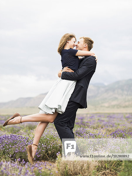 Ein frisch verheiratetes Paar umarmt sich in einem Lavendelfeld