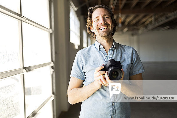 Lächelnder Mann mit Digitalkamera