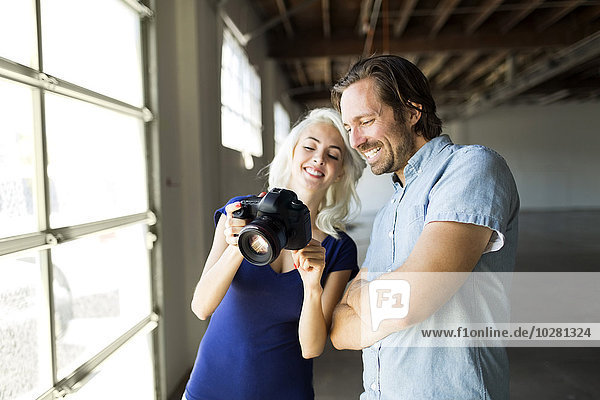 Woman and man looking at pictures in digital camera