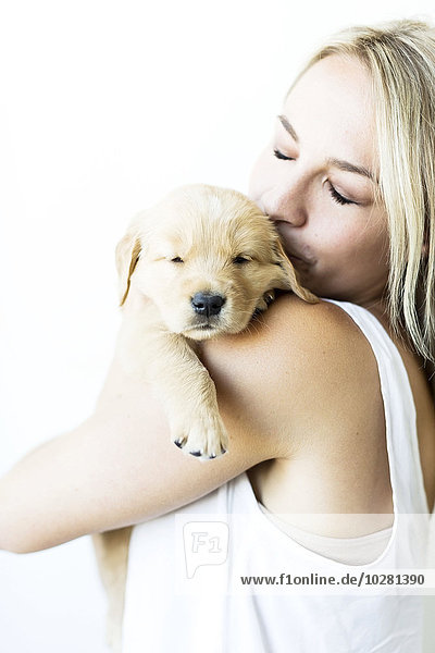 Studio shot of Golden Retriever puppy with owner