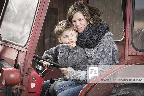 Frau mit Sohn im Traktor sitzend