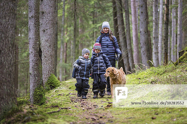 Mutter mit Söhnen beim Spaziergang im Wald