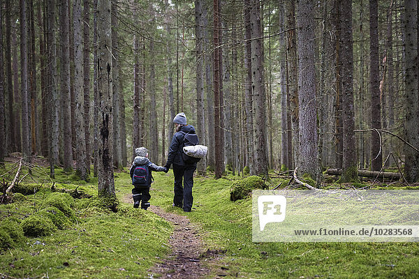 Mother with son walking in forest