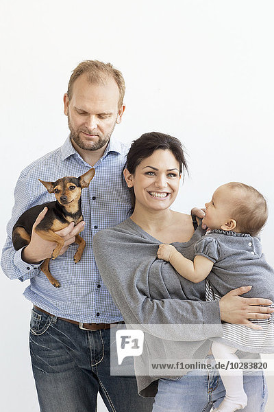 Eltern mit kleinem Mädchen und Hund