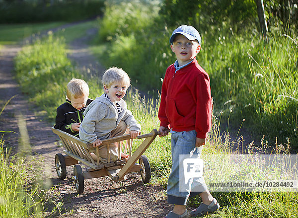 Children playing with wooden cart