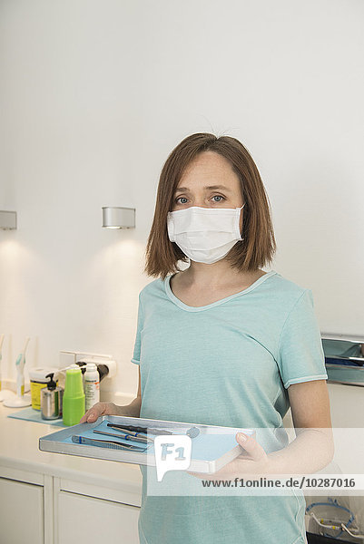 Zahnmedizinische Fachangestellte hält ein Tablett mit Werkzeugen in der Zahnklinik  München  Bayern  Deutschland
