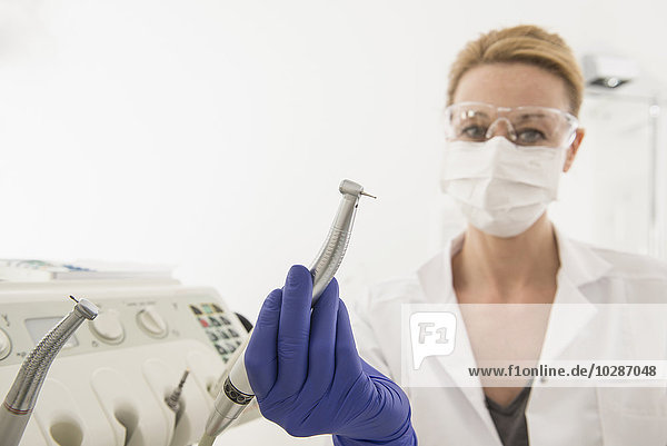 Female dentist holding dental drill  Munich  Bavaria  Germany