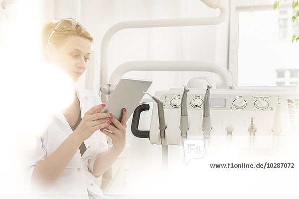 Female dentist using digital tablet in clinic  Munich  Bavaria  Germany