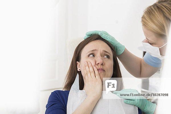Ärztin tröstet Patientin mit Zahnschmerzen  München  Bayern  Deutschland