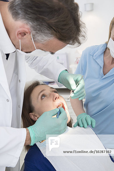Zahnarzt bei der Untersuchung eines Patienten  München  Bayern  Deutschland