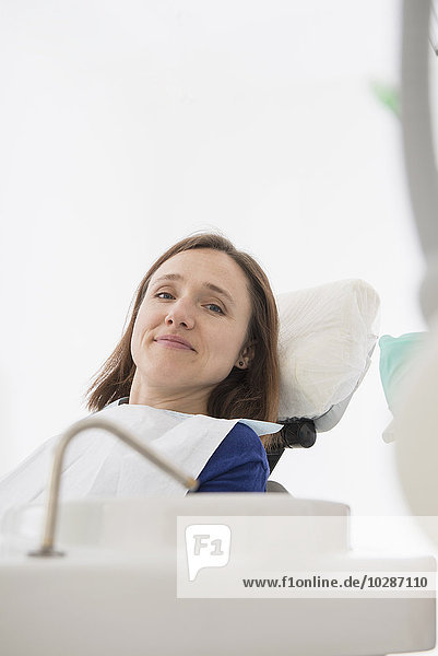 Happy patient on dentist's chair in dental clinic  Munich  Bavaria  Germany