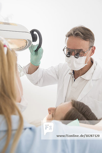Close-up of dentist examining patient with magnifiers on eyeglasses  Munich  Bavaria  Germany