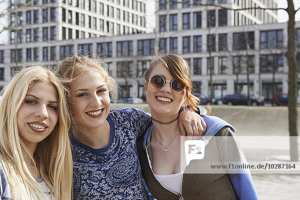 Three friends smiling in a playground  Munich  Bavaria  Germany
