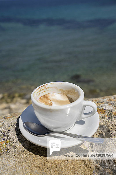 Tasse Kaffee auf einem Felsvorsprung am Meer  Apulien  Italien