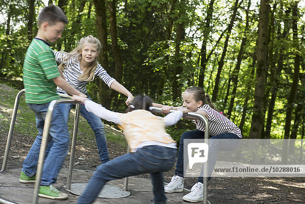 Kinder haben Spaß auf einem Karussell auf einem Spielplatz  München  Bayern  Deutschland